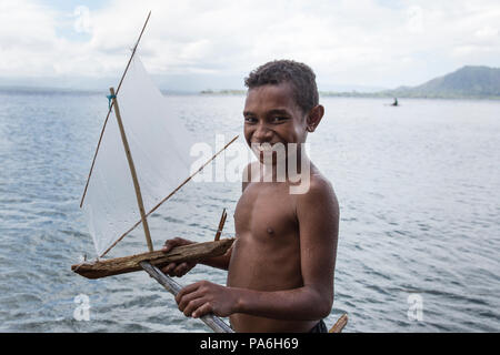 Ragazzo con il giocattolo artigianale barca, Papua Nuova Guinea Foto Stock
