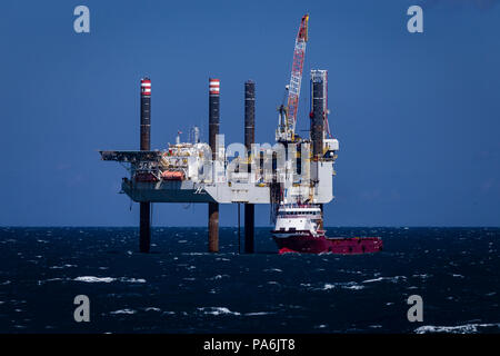 Il petrolio del Mare del Nord rig e suppoprt nave in mare calmo e sole Foto Stock