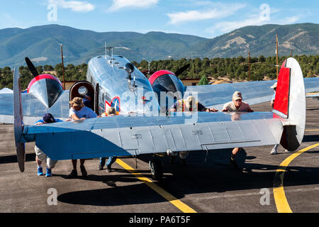 Volontari spingendo Beechcraft modello 18 alla pista di atterraggio; Twin faggio; UC-45J navigatore; BNS-1 Kansan; US Navy; Salida Fly-in & Air Show; Salida; Colorado; USA Foto Stock