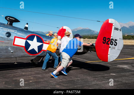 Volontari spingendo Beechcraft modello 18 alla pista di atterraggio; Twin faggio; UC-45J navigatore; BNS-1 Kansan; US Navy; Salida Fly-in & Air Show; Salida; Colorado; USA Foto Stock