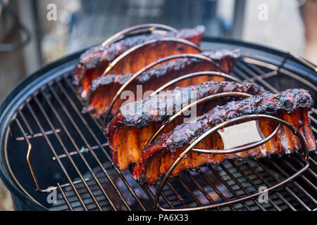 La cottura di una marinata di bimbo indietro nervature su un barbecue per esterni Foto Stock