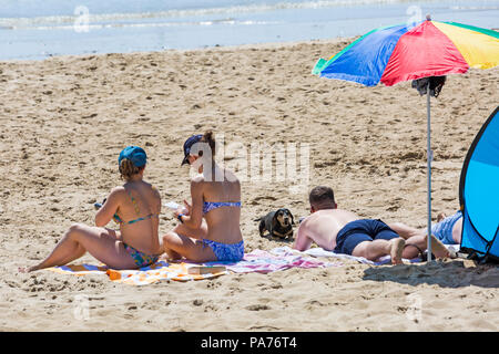 Bournemouth Dorset, Regno Unito. Il 21 luglio 2018. Regno Unito: Meteo Sole e caldo a Bournemouth spiagge, come testa sunseekers al mare a prendere il sole all'inizio dell'estate. Prendere il sole sulla spiaggia con salsiccia bassotto cane. Credito: Carolyn Jenkins/Alamy Live News Foto Stock