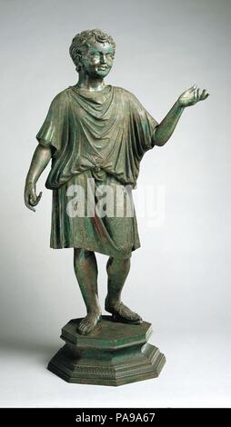 Statua di bronzo di un Camillo (accolito). Cultura: Romano. Dimensioni: H. 46 1/8 in. (117,1 cm). Data: ca. A.D. 14-54. Non appena ha preso il potere, l'imperatore Augusto ha messo in moto un programma volto a ripristinare il tempo onorato i valori di virtù, di onore e di pietà. Culti religiosi sono stati riproposti, templi furono costruiti, cerimonie pubbliche e sacrifici riempito il calendario. Gli uomini di ogni rango ha scelto di essere rappresentata nell'atto di sacrificio pie. Il popolare tipo di scultura visto qui hanno mostrato i ragazzi che hanno servito come accoliti a cerimonie religiose. L'identificazione di questa figura come un Camillo, un partecipare Foto Stock