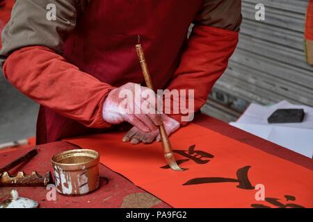 La calligrafia cinese scritto da un vecchio uomo prima che il nuovo anno cinese. Un carattere traduzione è persona. Foto Stock