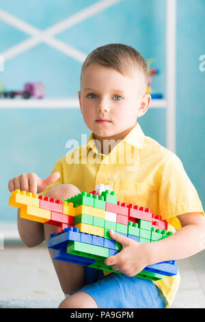 Ragazzo gioca a cubetti e il progettista della casa. Foto Stock