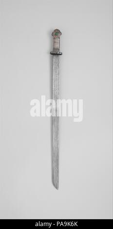 Spada (Ral gri). Cultura: tibetano. Dimensioni: L. 33 a. (83,8 cm); L. della lama 28 1/4 in. (71,8 cm); W. 2 1/2 in. (6,4 cm); D. 2 1/8 in. (5.4 cm); Wt. 2 lb. (907.2 g). Data: 17th del XIX secolo. Questa spada è un esempio rappresentativo della maggior parte familiare forma tibetana, ben fatti e di qualità abbastanza buona. La superficie della lama ha una forcina prominente pattern, una caratteristica importante della tradizionale tibetana di spade. Il modello si compone di sette linee scure alternate con sei linee di luce, causata dalla piegatura ripetuta di due differenti tipi di ferro che sono stati combinati per rendere la lama Foto Stock
