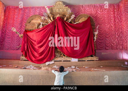 Bambino guardando pandal con Durga statua nascosto prima di iniziare di Durga puja celebrazione in Kolkata, India Foto Stock