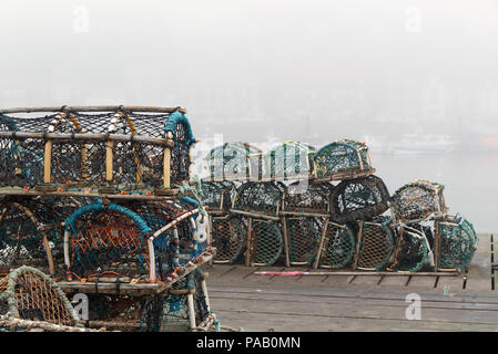 Lobster Pot sul porto di Whitby, North Yorkshire, Inghilterra con nebbia di mare su imbarcazioni in background. Profondità di campo. Il concetto di pesca Foto Stock