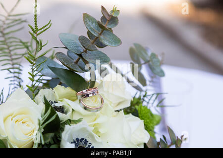 Bouquet di rose e gli anelli che giace sul tavolo Foto Stock