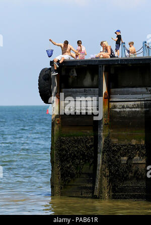 Le persone godono di un clima caldo e sulla spiaggia di whitstable kent, come il clima caldo continua. Foto Stock