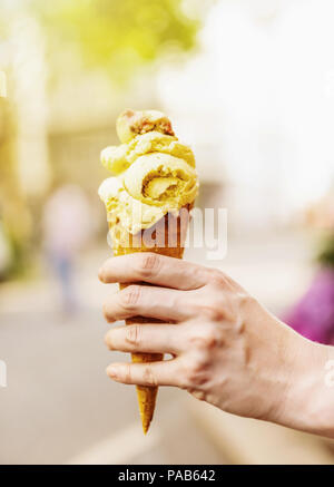 Femmina lato tenendo cono gelato Foto Stock