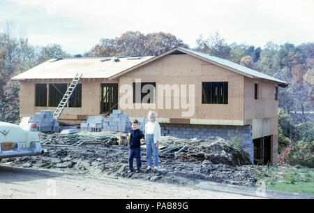 Nuova casa indipendente in costruzione con bambini, un ragazzo e un fratello e sorella tenendo le mani in piedi davanti, Briarcliff Manor, Westchester County, New York, USA negli anni '60 Foto Stock