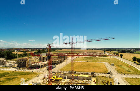 Sito in costruzione di gru e le conchiglie per case nuove, sullo sfondo la preparazione dell'area per il parcheggio di autovetture, foto aerea, realizzata con d Foto Stock