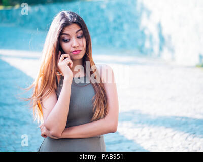 Indignati e insoddisfatto ragazza parla al telefono. Bella arrabbiato business donna litigare con qualcuno sulla strada. Slow motion. Emozioni, concetto tecnologico. Foto Stock