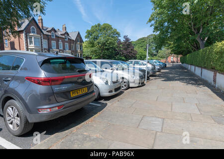 Fila di automobili parcheggiate perpendicolarmente al pavimento in una strada laterale a Lytham, Lancashire Foto Stock