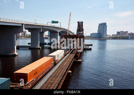 Treno caricato con i contenitori di spedizione attraversando il fiume del St Johns a Acosta bridge a Jacksonville, Florida Foto Stock