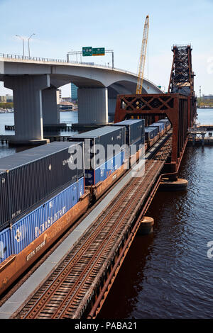 Treno caricato con i contenitori di spedizione attraversando il fiume del St Johns a Acosta bridge a Jacksonville, Florida Foto Stock