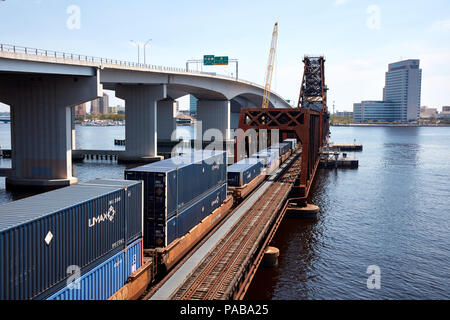 Treno caricato con i contenitori di spedizione attraversando il fiume del St Johns a Acosta bridge a Jacksonville, Florida Foto Stock