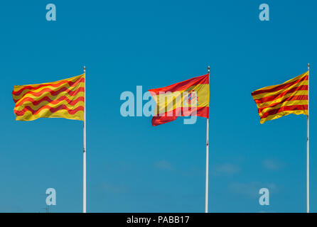 Catalano, Spagnolo e Tarragonian bandiere su un montante contro un cielo blu. La regionale del governo catalano vuole separare dalla Spagna Foto Stock