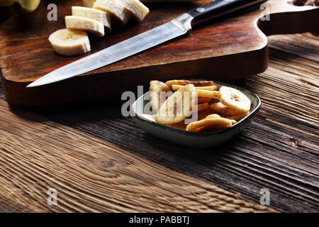 Banana chips, disidratato fette di fresche banane mature Foto Stock