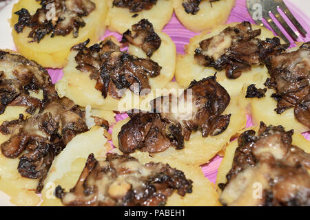 Close-up di un piatto con patate condito con funghi porcini Foto Stock