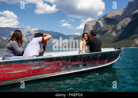 Lago Minnewanka, Banff, Alberta, Canada - 20 Giugno 2018: persone su una barca facendo scattare una foto durante una soleggiata giornata estiva. Foto Stock