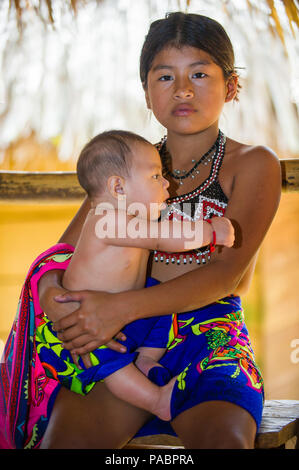 EMBERA VILLAGE, PANAMA, 9 gennaio 2012: Unidentified nativo ragazza indiana mantiene la sua sorellina in Panama, Jan 9, 2012. Indiano prenotazione è il modo in cui Foto Stock