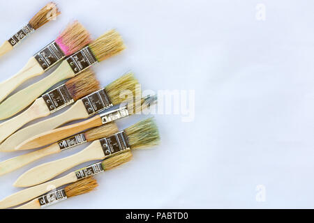 Usato pennelli per dipingere contro il libro bianco con spazio copia pronta per artwork Foto Stock