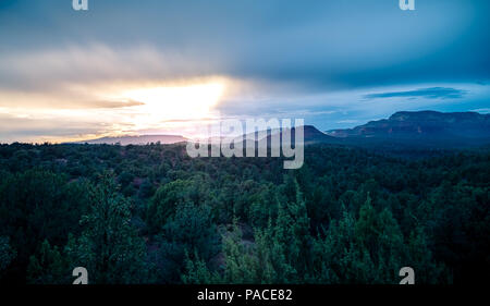 Un caldo sole estivo imposta oltre l'Arizona monti rossi di Sedona. Foto Stock