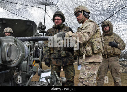 Troopers assegnato a Archer batteria, campo squadrone di artiglieria, 2° reggimento di cavalleria, dimostrare come funziona un M777 Obice di soldati tedeschi da 131tedesco battaglione di Artiglieria mentre partecipa nella loro unità di sistemi di artiglieria delle attività di cooperazione (ASCA) all'Grafenwoehr Area Formazione, situato vicino alla caserma di Rose, Germania, Marzo 16, 2016. Lo scopo di questo evento è stato quello di condurre operazioni di partenariato con il tedesco e l'esercito usa unità di artiglieria pur consentendo di ogni nazione ai soldati di esperienza cooperativa e coesivo formazione multinazionale. (U.S. Esercito foto di Sgt. William A. Foto Stock