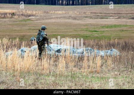 Stati Uniti Esercito il Mag. Cristopher Murphy, Comandante del 982nd combattere la Camera Co. (Airborne), si prepara a pacco il suo paracadute dopo un salto da un UH-60 Black Hawk elicottero durante il funzionamento Glück ab! (OGA), Fort Gordon, Ga., Marzo 4, 2016. OGA è un bi-laterale funzionamento airborne ospitato dall'esercito Cyber Centro di Eccellenza. Lo scopo di OGA è di promuovere e di coltivare il tedesco e le relazioni degli Stati Uniti, sviluppare l'interoperabilità durante il corso di formazione e di fornire una base per le future operazioni in formazione e in ambienti reali. Il combattimento 982nd fotocamera Company (airborne), la 421st Quartermaster Company, Foto Stock