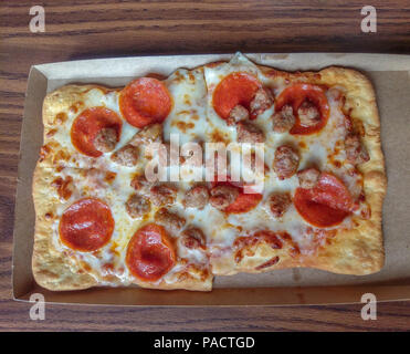 Piccolo salame e salsiccia per pizza pasta pizza su un piatto di carta Foto Stock