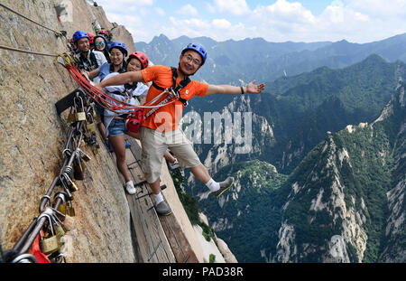 Pechino, la Cina della provincia di Shaanxi. 18 Luglio, 2018. I turisti posano per foto su Chang Kong Plank Road a Huashan Montagna in città Huayin, Cina nord-occidentale della provincia di Shaanxi, luglio 18, 2018. Credito: Tao Ming/Xinhua/Alamy Live News Foto Stock