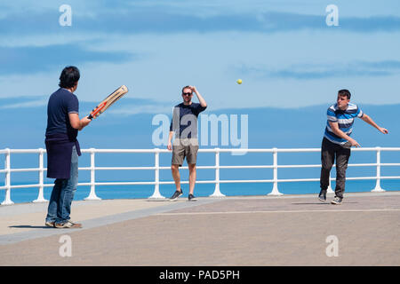 Aberystwyth Wales UK, domenica 22 luglio 2018 UK Meteo: giovani uomini giocano una improvvisata partita di cricket sul lungomare di Aberystwyth su un gloriosamente soleggiata Domenica mattina nel Galles occidentale. Il Regno Unito vasta ondata di caldo continua senza tregua dal clima assai secco e le temperature sono prevista supera 30ºC di nuovo entro la fine della settimana Photo credit: Keith Morris / Alamy Live News Foto Stock