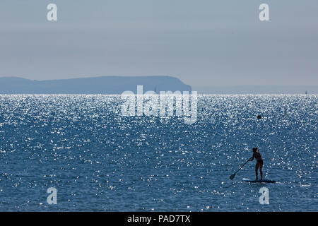 Bournemouth Dorset, Regno Unito. Il 22 luglio 2018. Regno Unito: Meteo Sole e caldo a Bournemouth spiagge, come testa sunseekers al mare a prendere il sole. Contre jour - silhouette di paddleboarder sparare in sun. Credito: Carolyn Jenkins/Alamy Live News Foto Stock