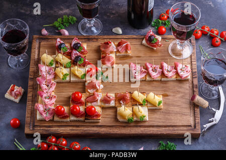 Spaghetti o autentici tradizionali tapas spagnole impostato per tavola da pranzo. Antipasti di condivisione su un partito o picnic estivo tempo blu su sfondo rustico. Vista superiore, piatto laici. Foto Stock