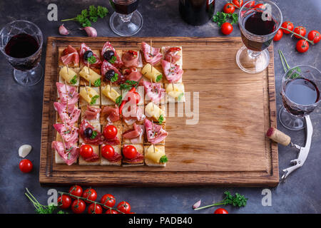 Spaghetti o autentici tradizionali tapas spagnole impostato per tavola da pranzo. Antipasti di condivisione su un partito o picnic estivo tempo blu su sfondo rustico. Vista superiore, piatto laici. Foto Stock