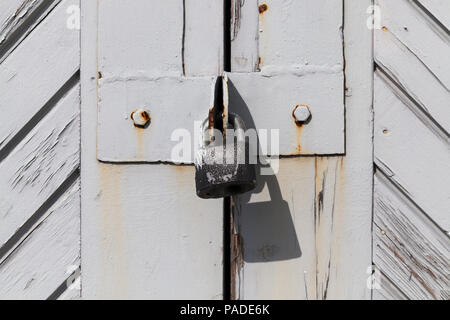 Rivestite e rinforzate con doghe in legno dipinto in grigio ante in legno, close-up, superficie verniciata non è perfetto e frantumato, la porta si blocca un ol Foto Stock