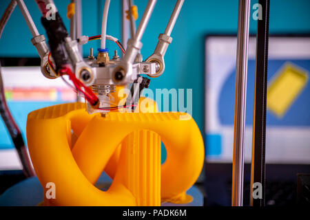 Stampa parti arancione su una stampante 3D nel processo di stampa Foto Stock