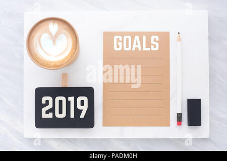 2019 obiettivi sul brown riciclare carta con matita,clip,lavagna matita,eraser e tazza di caffè in marmi bianchi e grigi table.mock up per aggiunta di testo,nuovo Foto Stock