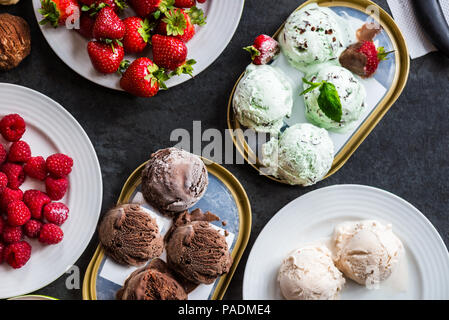 La selezione di diversi ice cream scoop come la menta, cioccolato e fragola su sfondo marmo, vista dall'alto Foto Stock