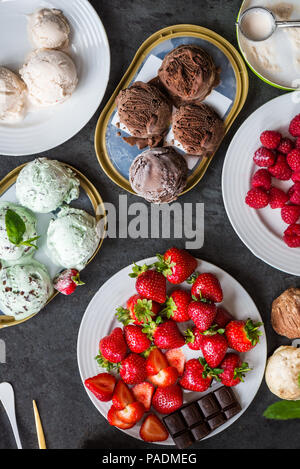 La selezione di diversi ice cream scoop come la menta, cioccolato e fragola su sfondo marmo, vista dall'alto Foto Stock