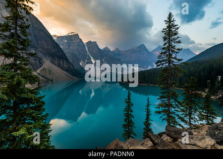 Sunrise con acque turchesi del Lago Moraine con il peccato accesa montagne rocciose nel Parco Nazionale di Banff del Canada nella Valle dei dieci picchi. Foto Stock