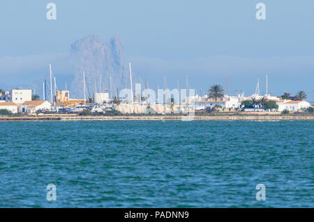 La Savina vista con navi a vela a montanti nel suo porto con Es Vedrá isolotto di lo sfondo di Estany Pudent (Parco Naturale di Ses Salines, Formentera,Spagna) Foto Stock
