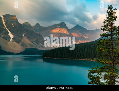 Sunrise con acque turchesi del Lago Moraine con il peccato accesa montagne rocciose nel Parco Nazionale di Banff del Canada nella Valle dei dieci picchi. Foto Stock