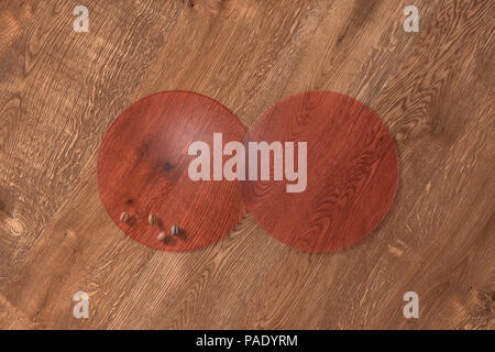 Due round rosso trasparente montagne russe e i chicchi di caffè su uno sfondo di legno. 3d illustrazione Foto Stock