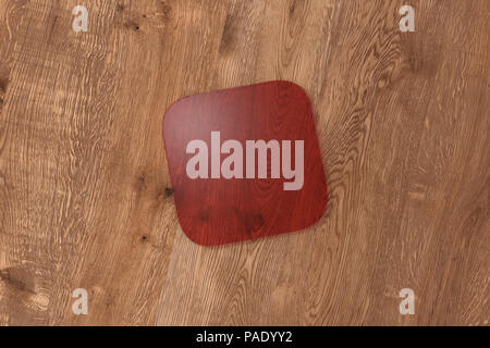 Quadrato Rosso trasparente coaster su uno sfondo di legno. 3d illustrazione Foto Stock