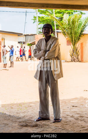 A Lomé, Togo - Mar 9, 2013: Non identificato uomo Togolese rimane all'esterno. Popolo del Togo soffrono di povertà a causa delle condizioni economiche instabili. Foto Stock