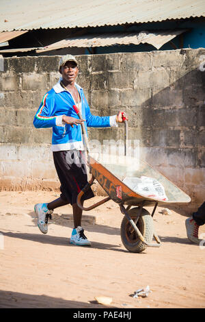 BANJUL (GAMBIA - Mar 14, 2013: gambiana non identificato piccolo uomo porta il carrello in Gambia, Mar 14, 2013. I principali gruppi etnici in Gambia è la mandi Foto Stock