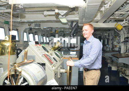 POLARIS POINT, Guam (30 marzo 2016) - Alec Johnson, un militare assistente legislativo, pone con il timone della Emory S. Land-class submarine offerta USS Frank cavo (come 40) durante una nave del tour di marzo 30. Cavo di Frank, distribuito per l'isola di Guam esegue la manutenzione e il supporto dei sommergibili e navi di superficie distribuiti negli Stati Uniti 7 flotta area di responsabilità. (U.S. Navy foto di comunicazione di massa marinaio apprendista Alana Langdon/rilasciato) Foto Stock